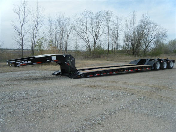 Talbert 55CC-HRG-T1 lowboy trailer in a field showing the long flat deck and triple axle configuration.