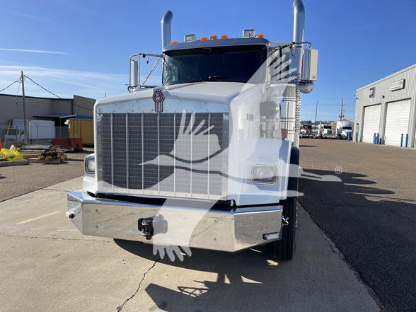 Kenworth T800 truck front view showing large grille, chrome bumper, round emblem on hood, dual tall exhaust stacks, and rectangular headlights.