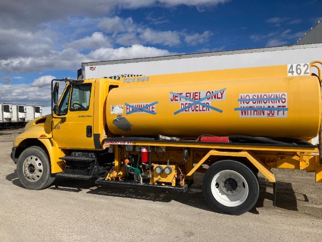 Fuel tanker truck in yellow with VT365 engine label and refueling equipment visible on side tank.