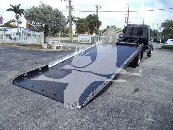 2014 Hino 258ALP tow truck with a large flatbed ramp extended for loading.