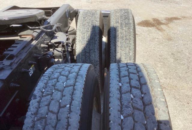 Peterbilt truck chassis showing dual rear axles with dual tires and road grime on tread.