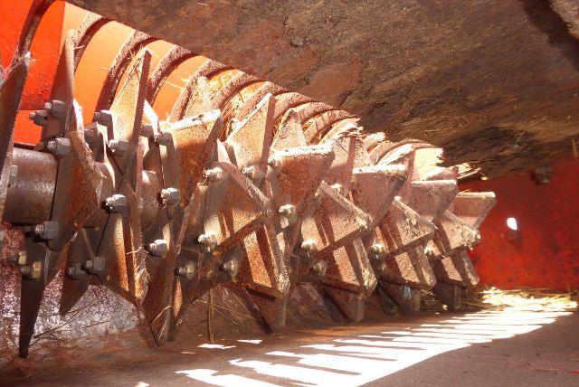 Agri-Metal CA8064 agricultural implement with metal auger blades and bolts in a dusty orange frame, horizontal orientation.