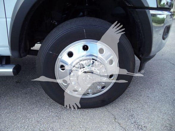 Ram 5500 wheel and tire assembly with chrome hubcap and front fender view.