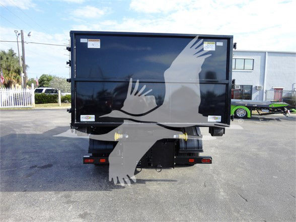 Back of a 2023 Chevrolet Silverado 5500HD dump truck bed with two yellow hitch pins and a black trailer hitch; reflective logos and stickers on the container.