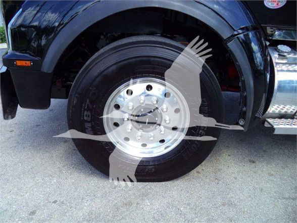 Kenworth T880 front wheel and tire assembly showing polished aluminum wheel and tire sidewall.