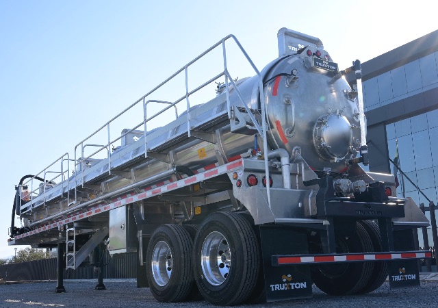 TruxTon 150BBL aluminum non-code vacuum trailer viewed from rear-left, showing tandem axle with large cylindrical vacuum tank and rear access/platform rails.