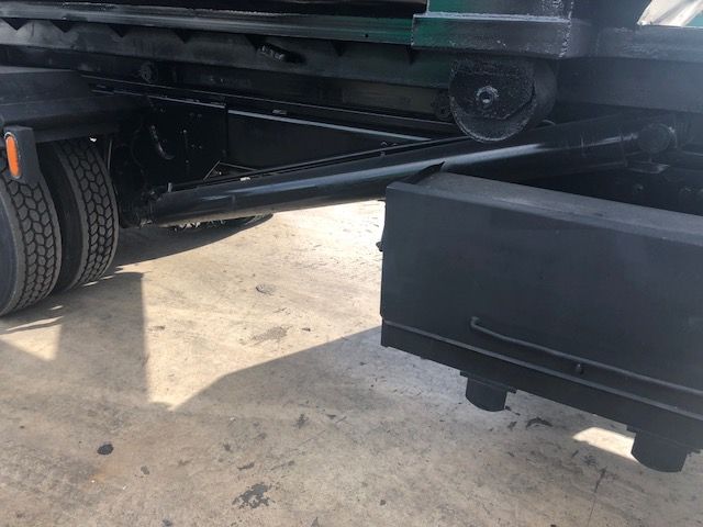 Freightliner M2-112 undercarriage showing hydraulic lines and underbody components near the rear wheels.