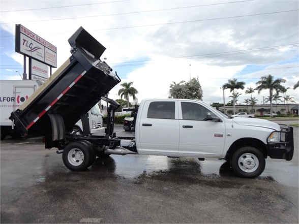 Ram 3500 dump truck in profile view showing raised black dump bed and white cab.