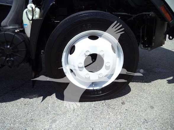 Isuzu NPR HD truck front wheel and fender area with white wheel and black tire visible.