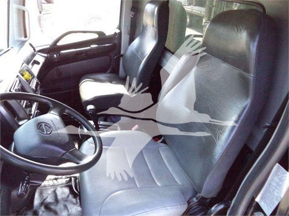 Truck cab interior with driver and passenger seats, steering wheel, dashboard visible.