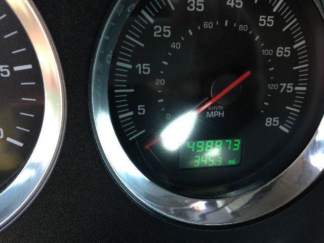 Dashboard gauge cluster showing speedometer with odometer reading 498,?73 and 345.3 miles display; green digital readout on a Kenworth truck dash.