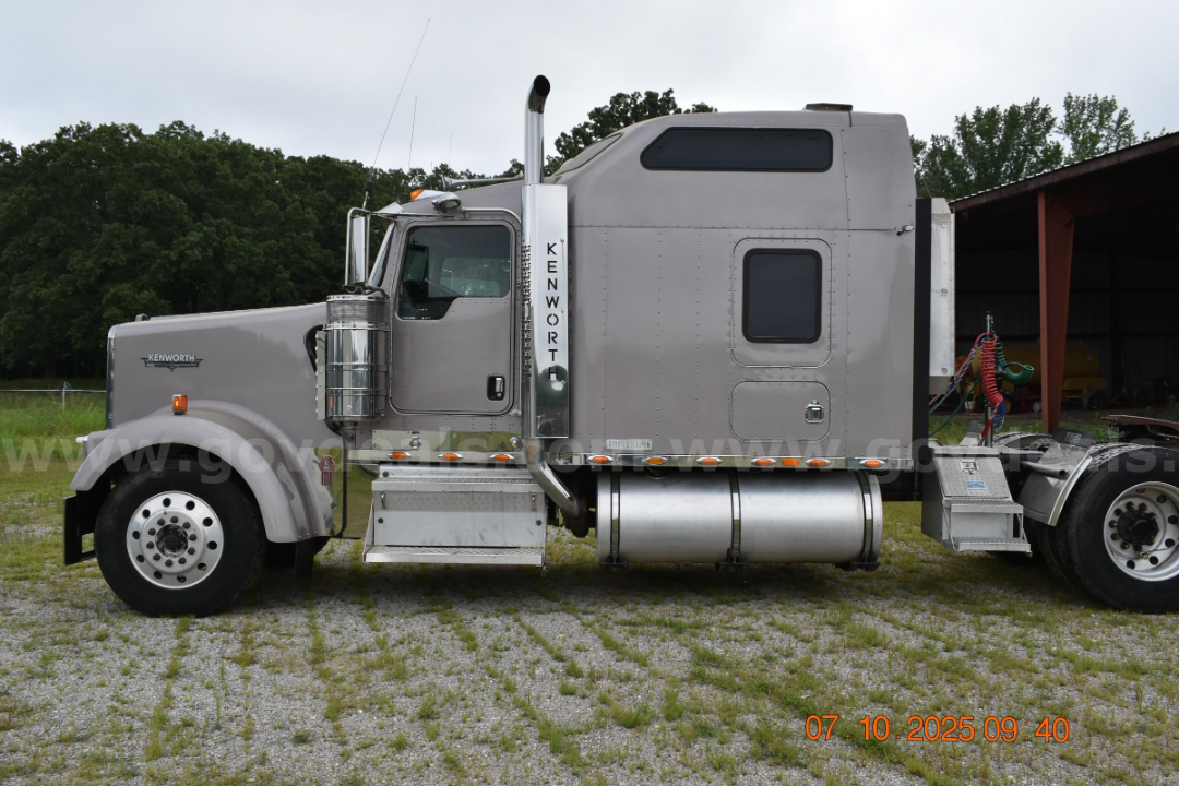 Kenworth W900 cab and chassis side view showing chrome fuel tanks and vertical exhaust stack.