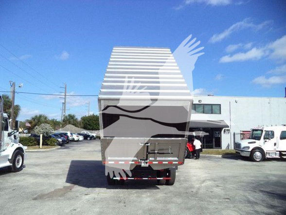 Back view of a 2019 International DURASTAR 4300 dump truck with a silver dump bed and chrome bumper, in a dealership lot.