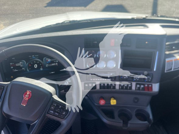 Kenworth T880 dash view showing steering wheel with Kenworth emblem, instrument cluster, center console with gauges and control switches.