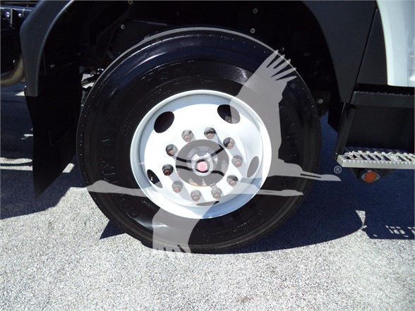 Isuzu FTR wheel and front fender showing steel wheel with multiple lug nuts and wheel hub in a tow truck.