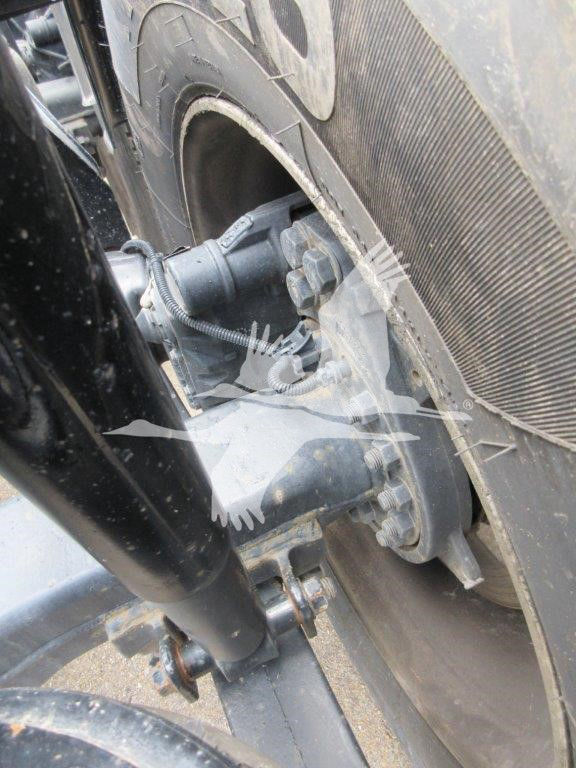Wheel assembly of a 2022 Kenworth W900B showing steering/linkage and tire details.