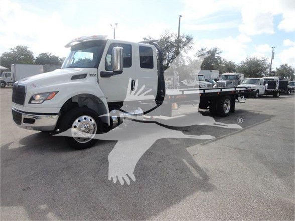 MV truck cab and flatbed under a clear sky showing International MV5? cab with side mirror, wheel, and towing bed.