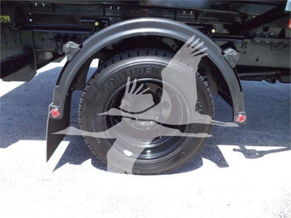 Trunk or rear wheel area of a 2023 International CV refuse truck showing a spare tire mounted with fenders and frame, visible wheel and tire with lettering.