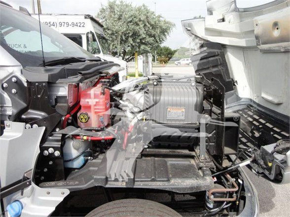 Chevrolet Silverado 6500HD engine bay showing battery, coolant reservoir, and wiring harness in front truck area.