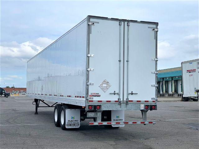 Manac dry van trailer with white exterior, two rear doors, viewed from rear-left angle.