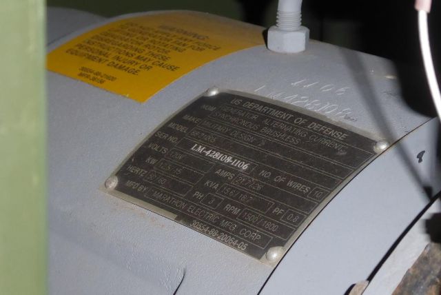 Label plate on machinery with Department of Defense markings, serial numbers, amps, and model information visible.
