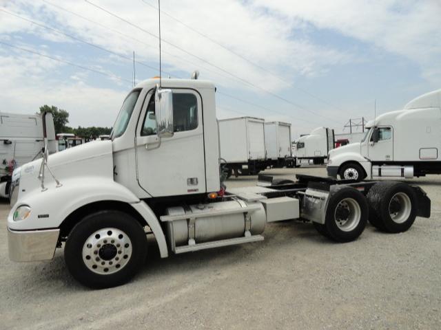 Freightliner Columbia 2009 conventional daycab tractor side view showing rear dual axles and fuel tanks.