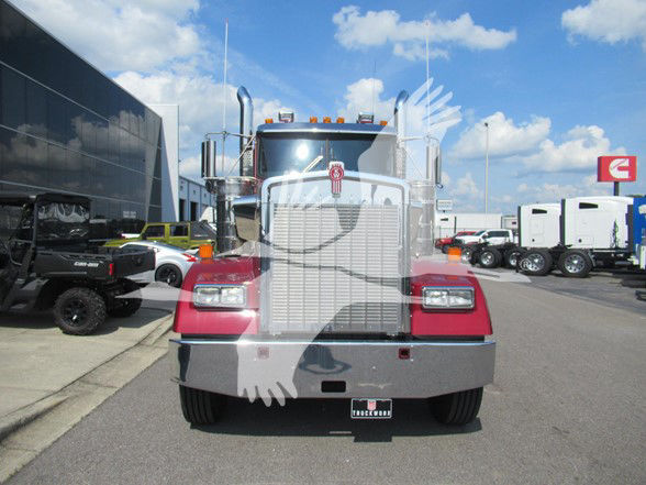 Kenworth W900L truck front view with chrome grille and large bumper in dealership lot.