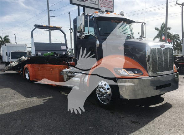 Peterbilt 337 cab with a custom orange flatbed trailer on dealership lot.