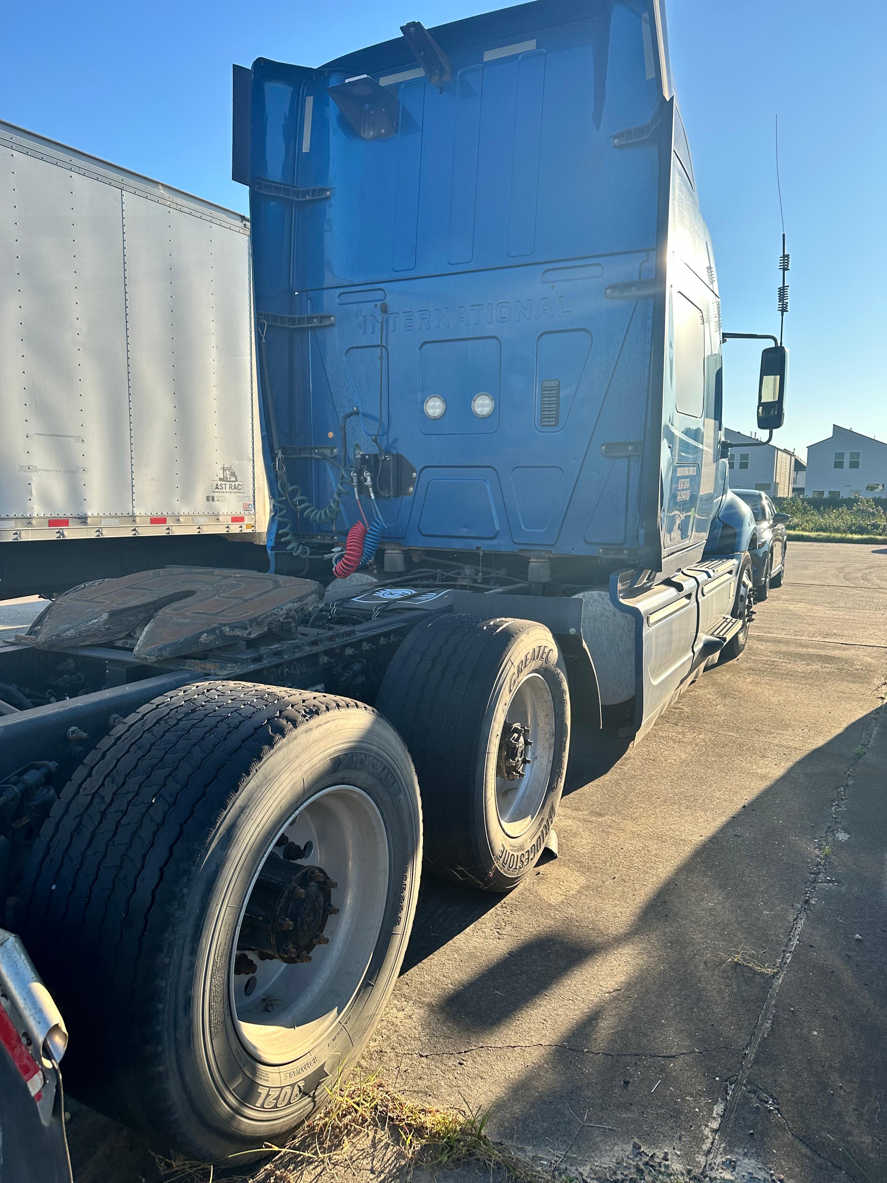International truck sleeper cab rear with dual rear axles and blue exterior, showing coupling area and rear tires.