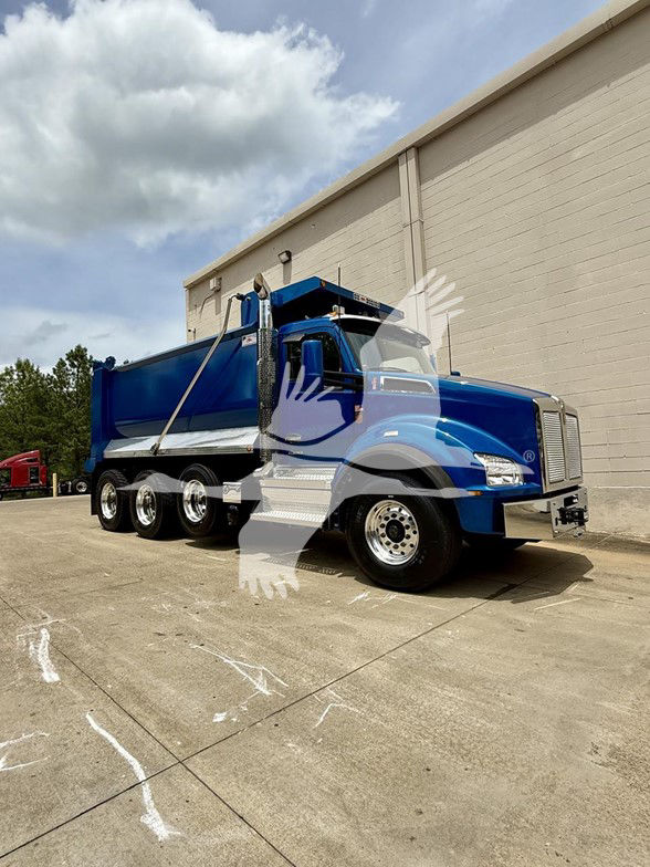 Kenworth T880 dump truck in blue, side view showing bed and dual rear axles.