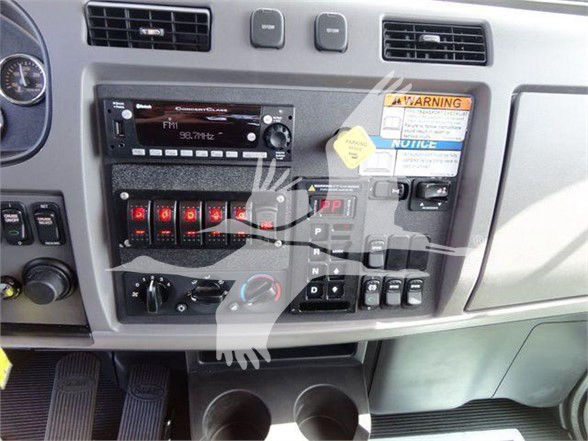 Peterbilt truck interior dash showing radio, control panel, switches, and gear shifter area.
