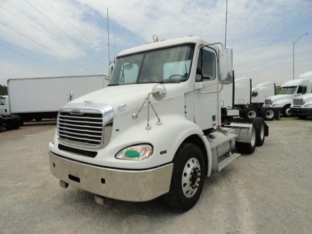 Truck cab front-left view showing 2009 Freightliner Columbia conventional daycab with chrome grille, large bumper, and dual rear axles.