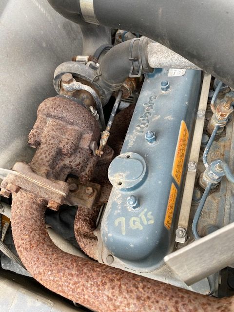 Kesmac F5000 engine bay showing intake manifold and exhaust manifold with rusted turbocharger and blue valve cover labeled with indistinct writing.