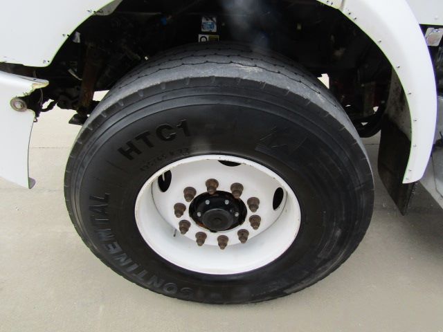 Truck wheel and tire on a Peterbilt 330 front axle showing Bridgestone tire and white rim.