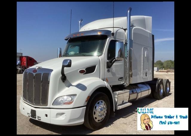 Peterbilt 579 conventional sleeper truck showing front grille, chrome bumper, and side chrome fuel tanks.