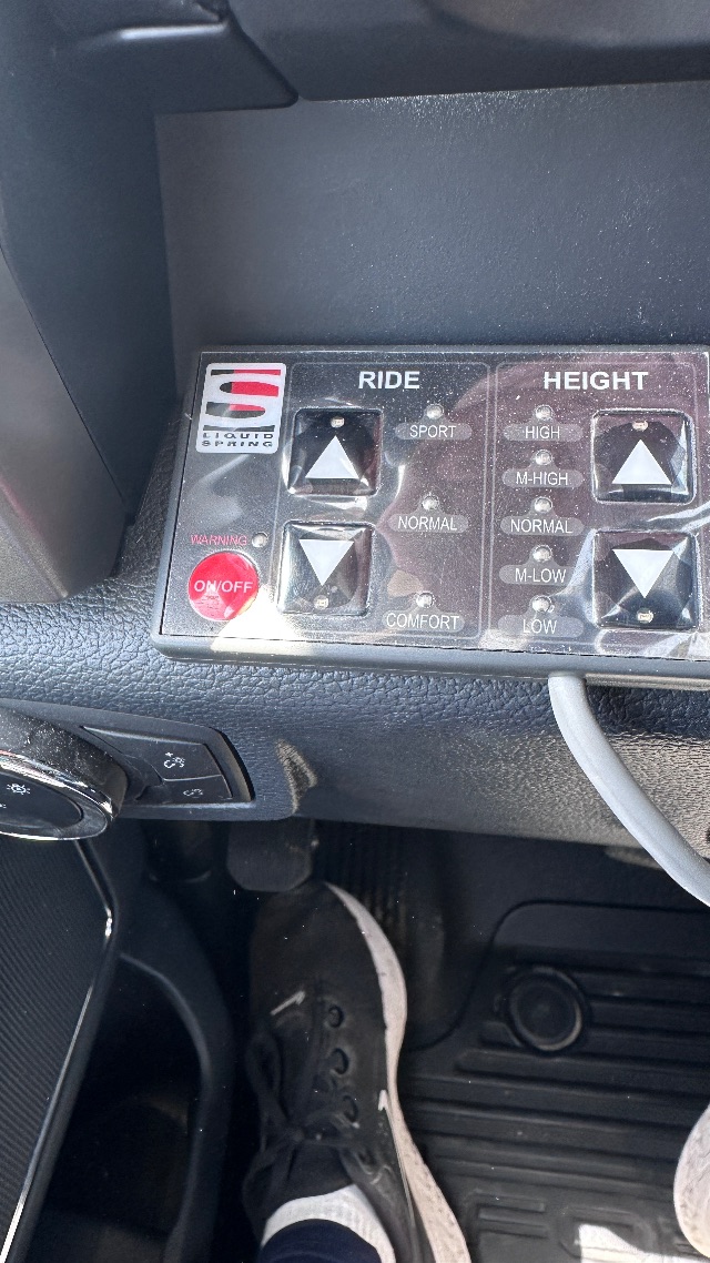 In-car control panel showing ride height adjustments with Sport/Normal/Comfort modes and various high/low height levels.