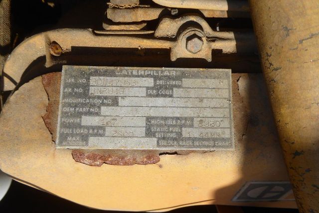 Caterpillar V225 forklift identification plate with serial numbers and specifications partially legible; metal plate mounted on yellow equipment showing model, serial, and load ratings.