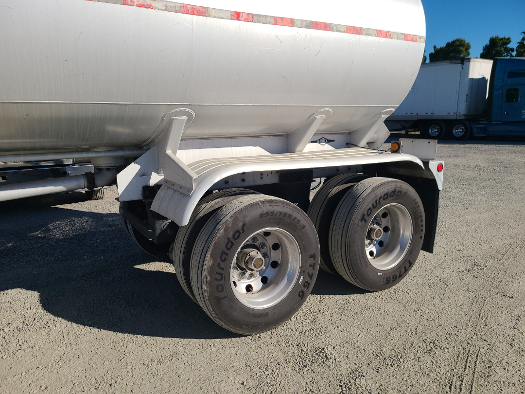 Trailer rear with dual-axle wheels and aluminum fuel tank, Beall semi-trailer with Tougadoro tires showing 205/75R/14? text on tires.