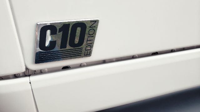 Trucking exterior showing a C10 Edition badge on a white International conventional sleeper truck.