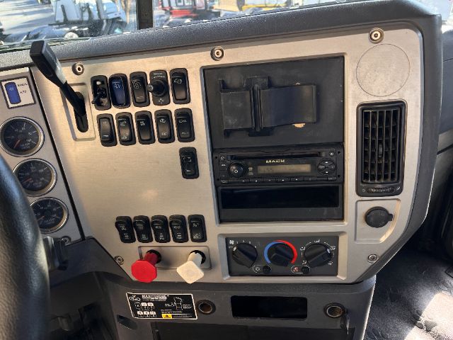 Dashboard panel of a 2013 Mack CHU613 Pinnacle truck showing HVAC controls, radio, switches, and gauges.