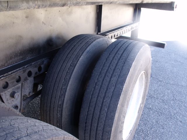 Trailer axle area with dual rear tires and undercarriage components visible; no legible branding or model text visible.