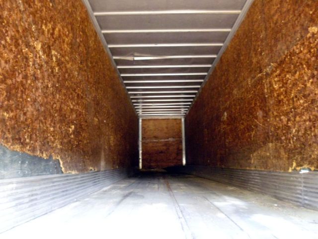 Trailer interior with wooden side walls and metal ceiling, long enclosed cargo space
