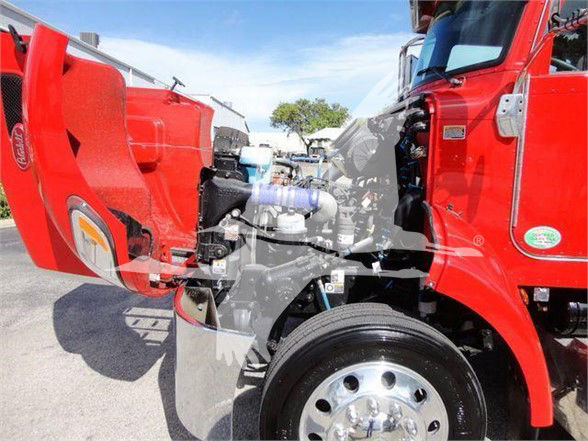 Peterbilt 337 truck engine bay with red cab, showing front wheel and intake components.