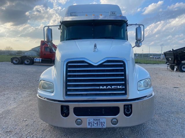 Mack CXU613 front view showing large chrome grille, white cab, Texas license plate R52-9702, LED headlights, side mirrors.