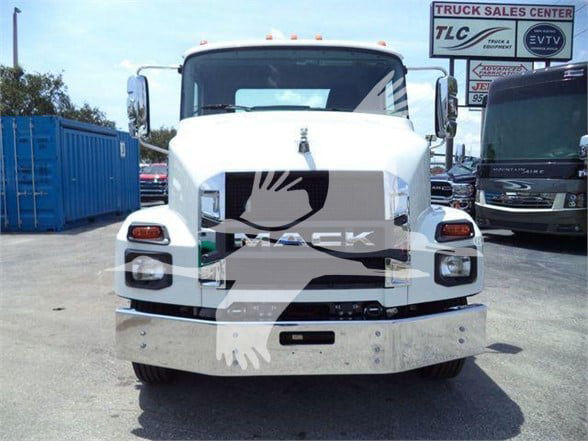 Front view of a white 2024 Mack MD6 truck with a large chrome front bumper and grille, Mack logo badge, and headlamps.