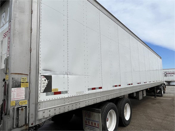 Great Dane 2015 dry van trailer side view showing tandem axles and white reflective decals.