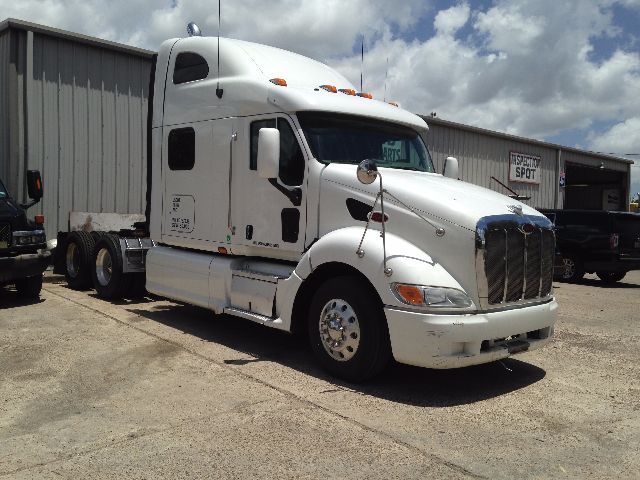 2008 Peterbilt VN truck in a lot, white long-hood sleeper with dual rear axles, front grille, and side mirrors.