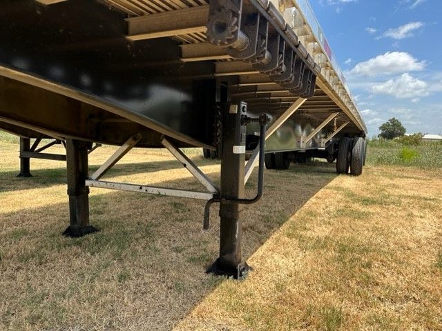 Flatbed trailer with support legs extended showing undercarriage and frame, 2019 Utility flat bed trailer 48x102.
