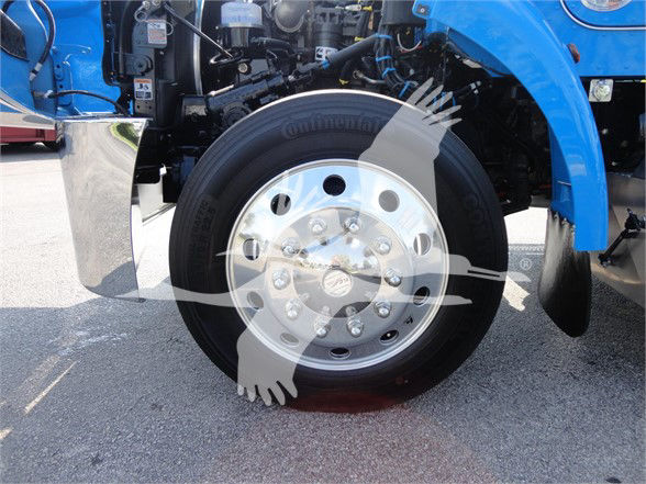 Peterbilt 337 front wheel assembly with Continental tire and shiny aluminum hubcap; blue truck body visible in background.
