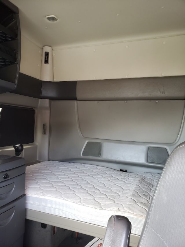 Interior cab of a 2015 International PROSTAR sleeper with a single bed, light gray walls, and quilted mattress.